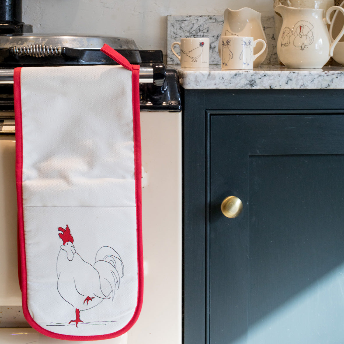 oven gloves with a rooster design and red underside