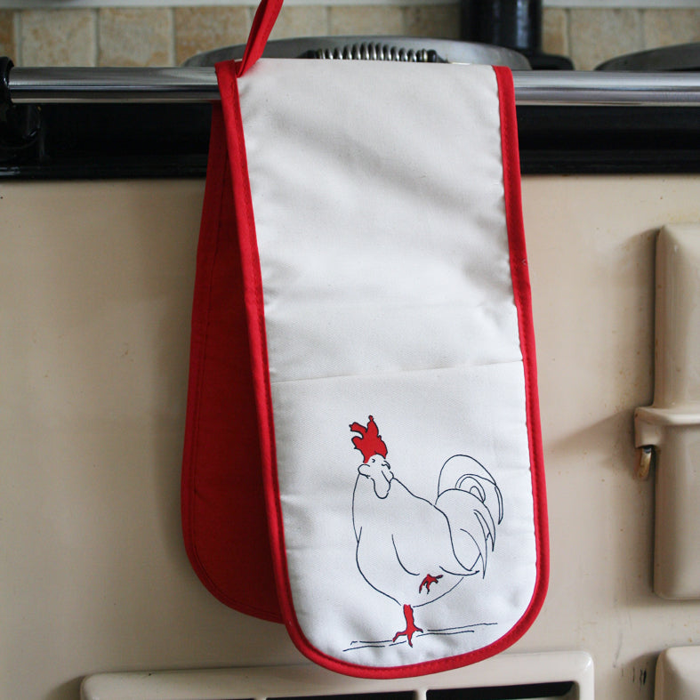 oven gloves with a rooster design and red underside on an aga